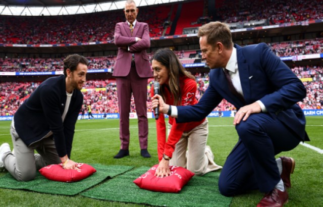 Footballer Tom Lockyer and the BHF's Lizzie Moscardini lead a CPR demo at Wembley Stadium with Vinnie Jones watching on.